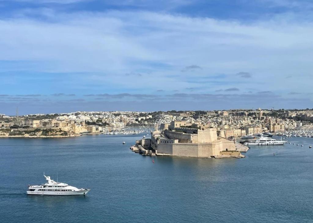 łódź w dużym zbiorniku wody z miastem w obiekcie Battery House w mieście Valletta