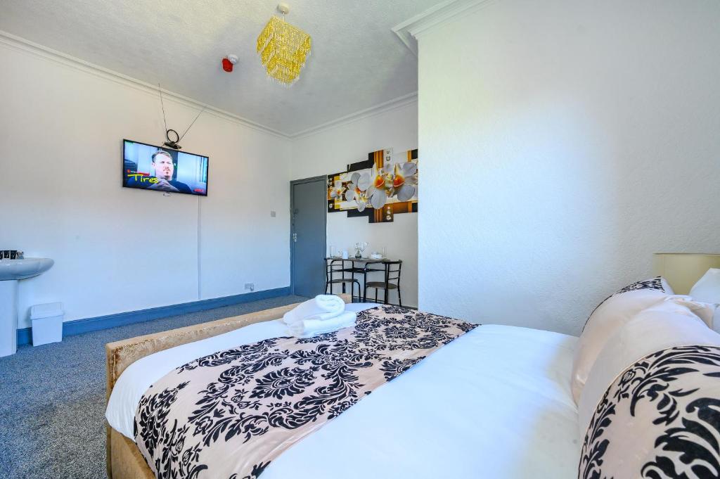 a bedroom with two beds and a tv on the wall at -RE7H- For your relaxed & Cosy Free Parking in Leeds