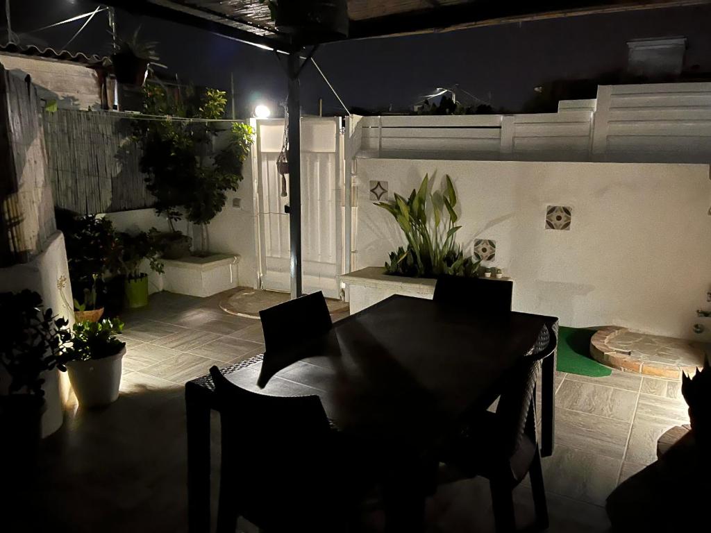 une chambre sombre avec une table, des chaises et des plantes dans l'établissement Holiday Rooms Ninfa, à Avola