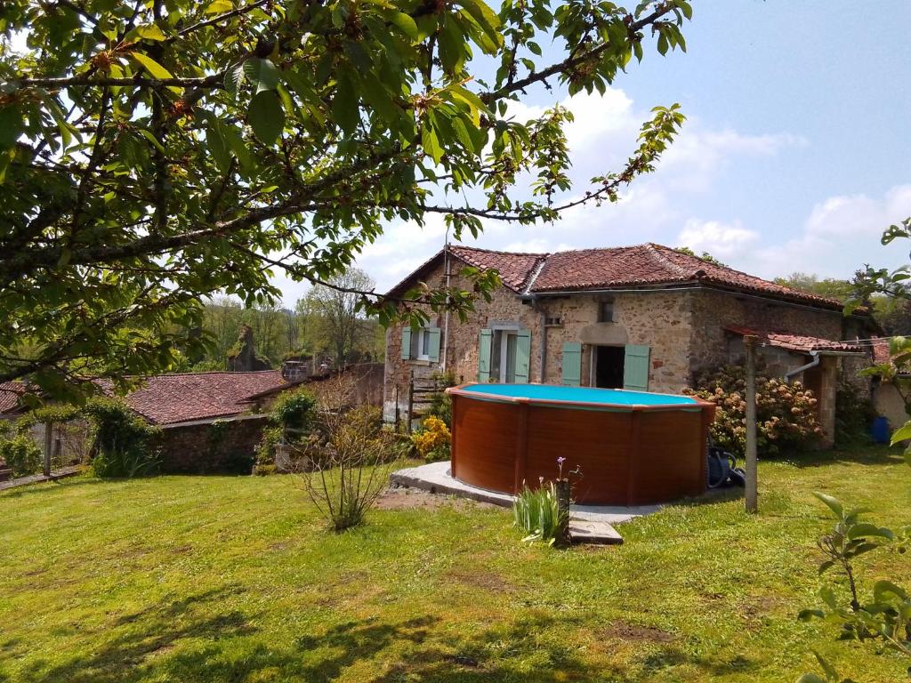 a house with a hot tub in a yard at Cottage by the Chateau with pool in National Parc in Les Salles-Lavauguyon