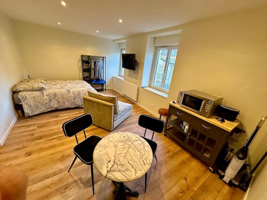 une chambre avec un lit, une table et des chaises dans l'établissement Studio au cœur de la Ville fortifiée, à Boulogne-sur-Mer