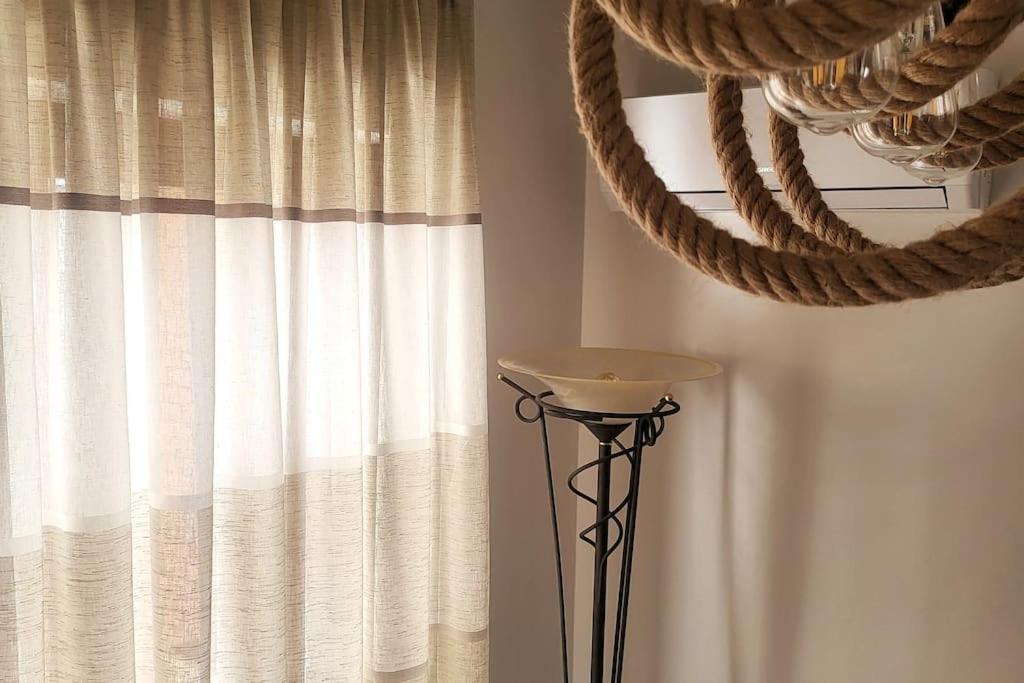 pokój z zasłoną i wazonem obok okna w obiekcie Acropolis w Atenach