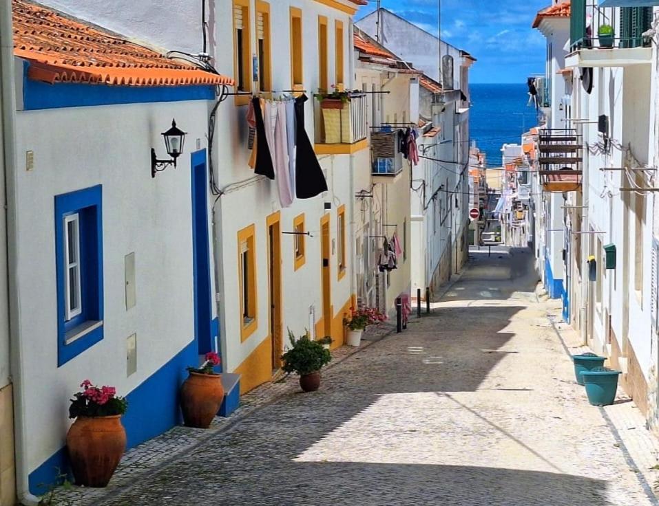 an alley in a town with blue and white buildings at Cabana Sete Ondas in Nazaré