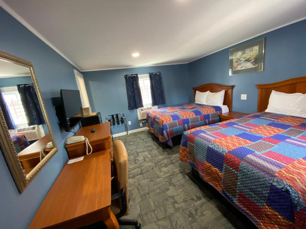 Habitación de hotel con 2 camas y espejo en Royal Inn en Claremont