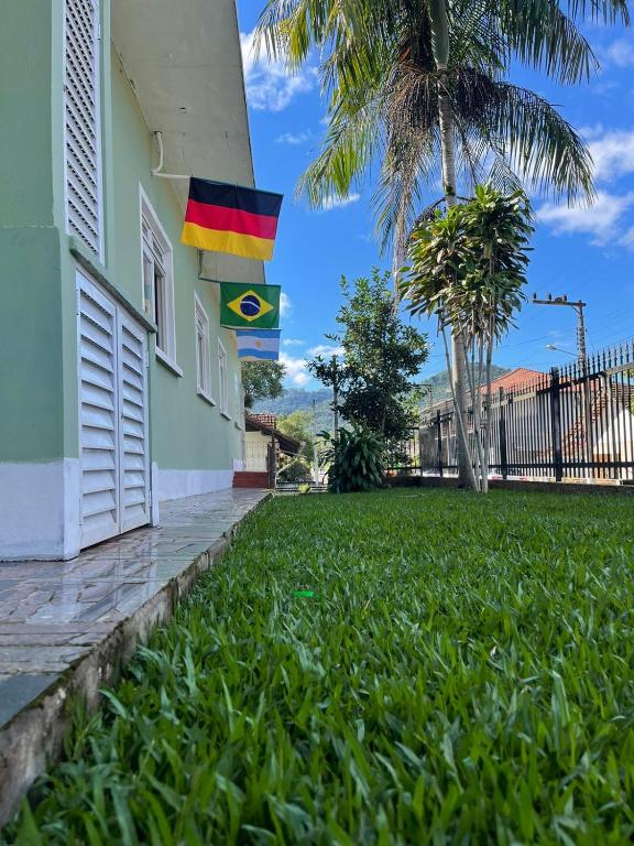 a flag on the side of a building with a grass yard at Hospedagem Dona Ester in Pomerode