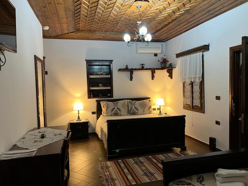 a bedroom with a bed and a couch and a table at Hotel Kaceli in Berat