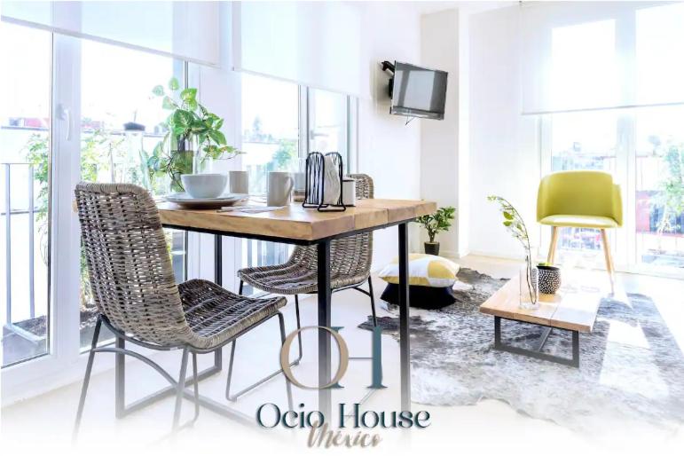 een eetkamer met een tafel en twee stoelen bij Esquina mágica en el mejor edificio del Centro Histórico in Mexico-Stad