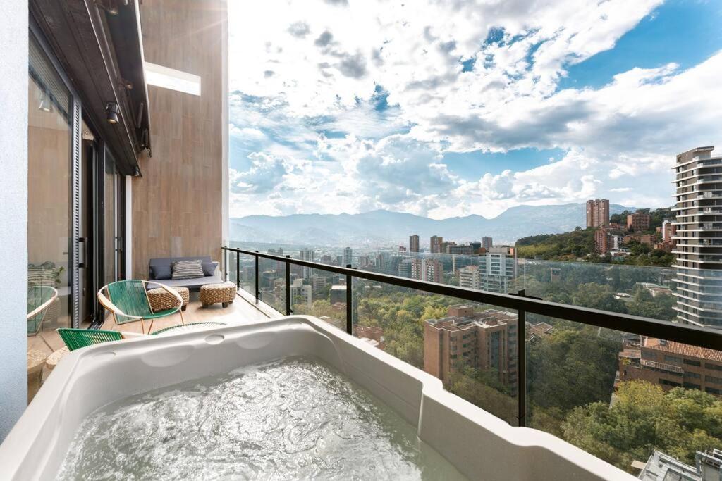 a bath tub sitting on top of a balcony with a view at Energy Living - Ultimate Condo in Medellin in Medellín