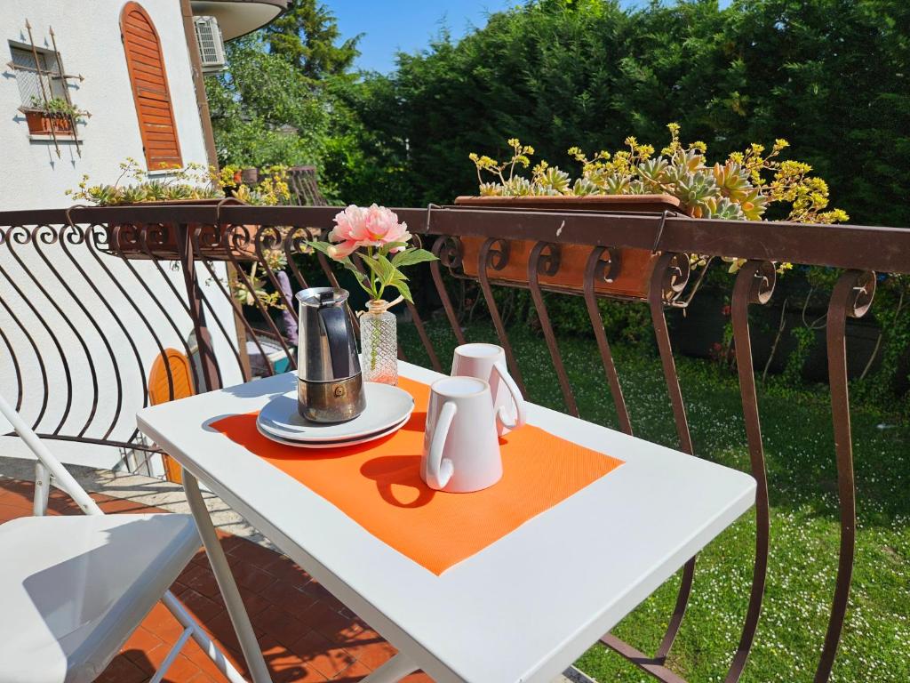 een tafel met een theeservies op het balkon bij Casa Olympia in Peschiera del Garda