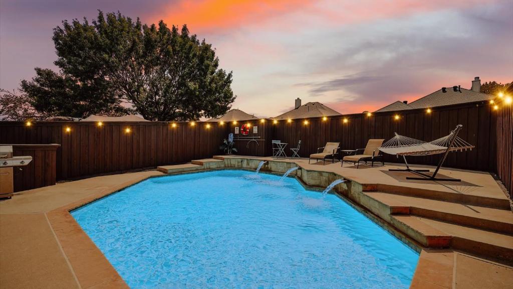 a swimming pool in a backyard with a fence at Luxe Retreat-5BR Oasis with sparkling pool & gaming in Mesquite