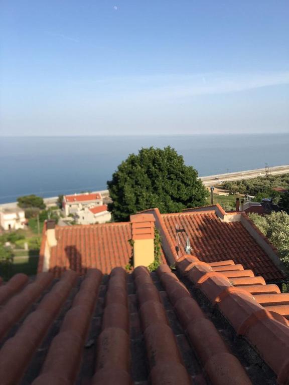 einen Blick auf das Dach eines Gebäudes mit Meerblick im Hintergrund in der Unterkunft Villa Velika GR in Velika