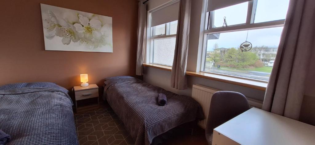 um pequeno quarto com 2 camas e uma janela em Private room, close to a swimming pool em Reykjavík