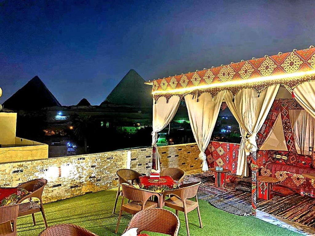 um pátio com uma mesa e cadeiras e um edifício em Arena pyramids view no Cairo