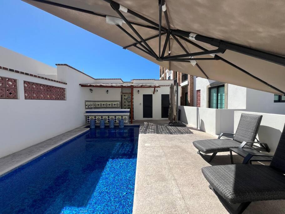 a swimming pool in a house with chairs and an umbrella at ¡Condominio céntrico en La Paz! in La Paz