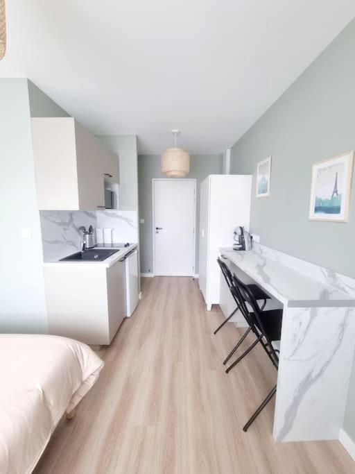 Cette chambre blanche dispose d'un lavabo et d'un bureau. dans l'établissement L'aiglon de Foch 1#ACCES FAC#, à Grenoble