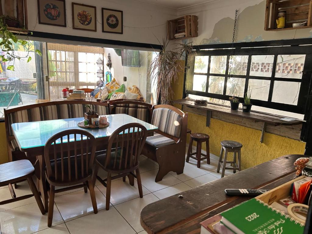 a restaurant with a table and chairs and windows at Taberna Hostel in Cabo Frio