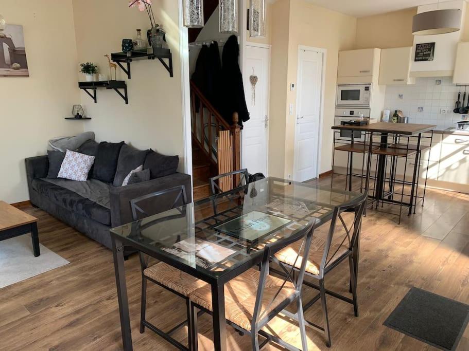 un salon avec une table en verre et un canapé dans l'établissement Charmante maison de campagne avec piscine, à Saint-Julien-aux-Bois