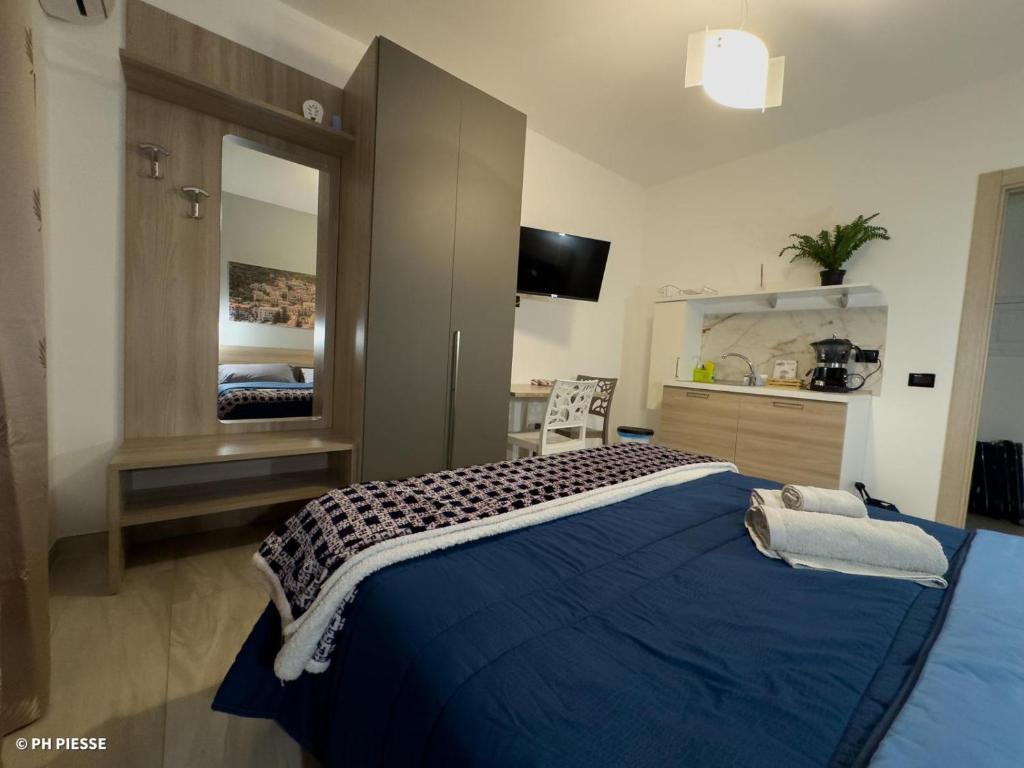 a bedroom with a blue bed and a mirror at B&B Alba Chiara in Paola