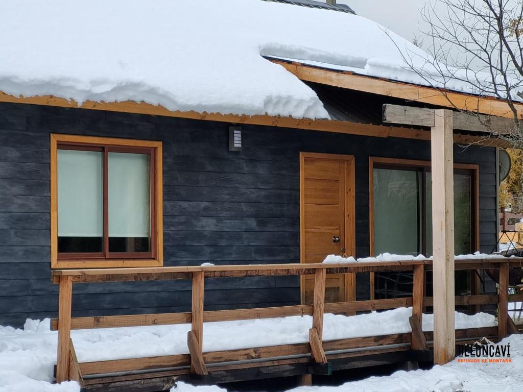 a cabin with a deck in the snow at Refugios de Montaña Reloncaví - Ruka Lee I in Las Trancas