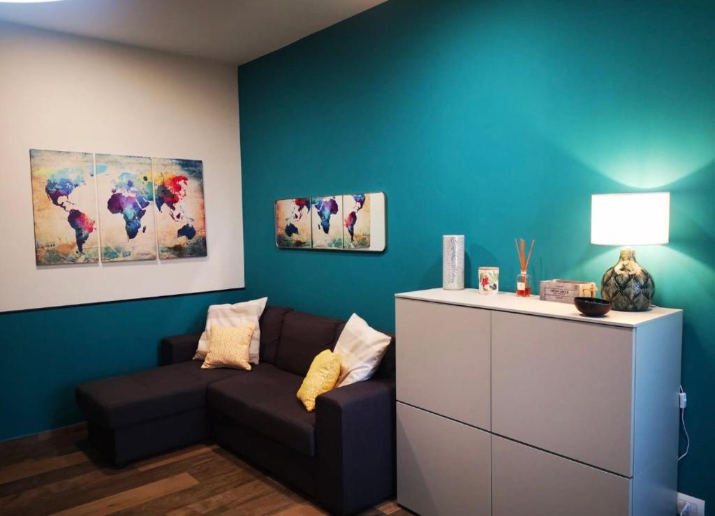 Una sala de estar con un sofá y una pared azul. en Casa Camilla, en Grosseto