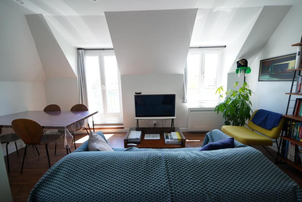 un soggiorno con divano blu e tavolo di Appartement de Paul ad Aurillac