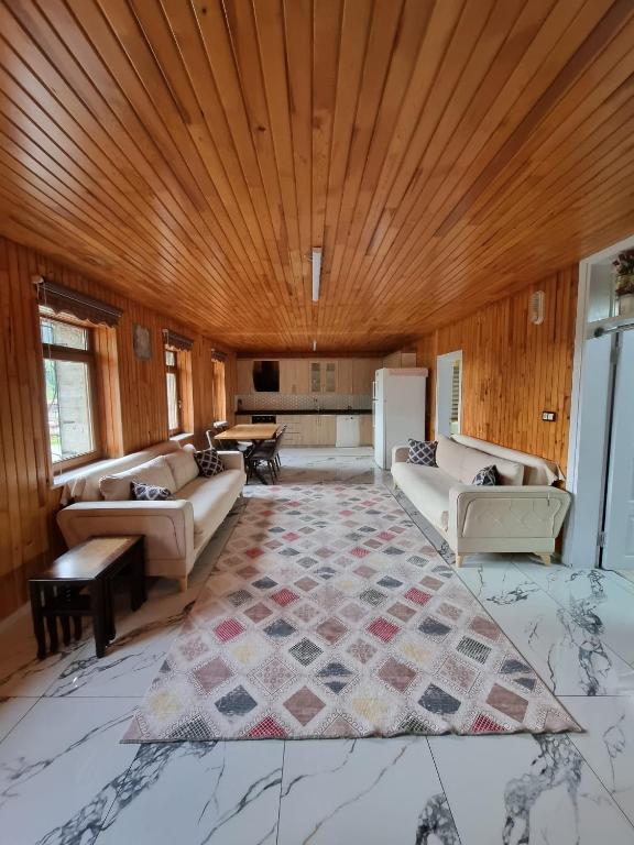 een woonkamer met banken en een houten plafond bij Özkan Apart in Çaykara