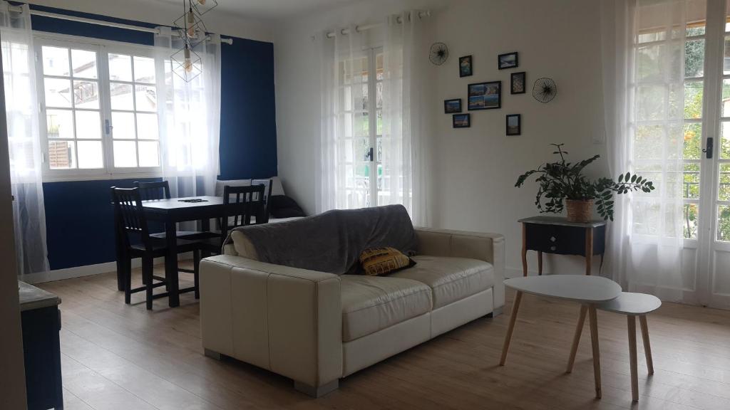 a living room with a white couch and a table at chez steph in La Trinité