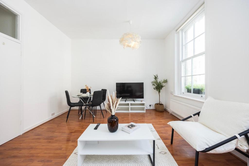a living room with white furniture and a table at Spacious 1 BR London Bridge in London