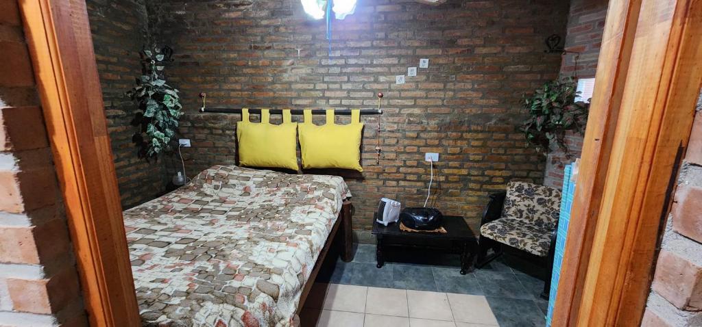 1 dormitorio con cama y pared de ladrillo en Casa En Cura Brochero Para Una Familia De 5/6 Pers. Todas las comodidades en Villa Cura Brochero