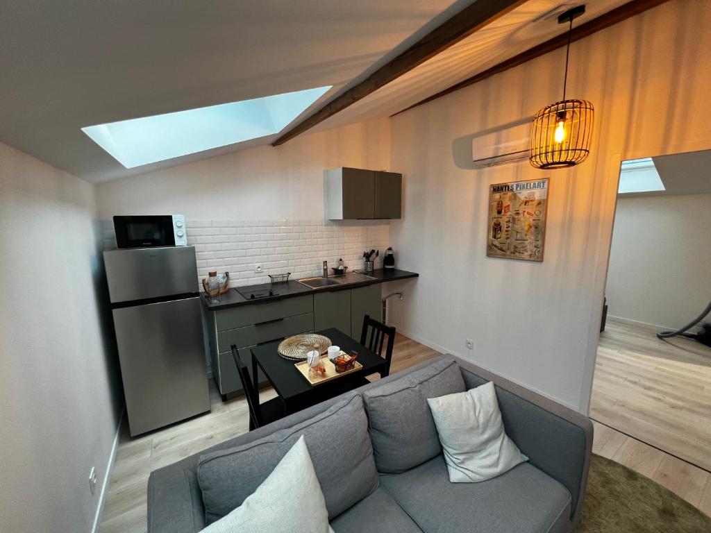 Il comprend un salon avec un canapé et une cuisine. dans l'établissement Hébergement indépendant proche aéroport Nantes Atlantique, à Saint-Aignan-Grand-Lieu