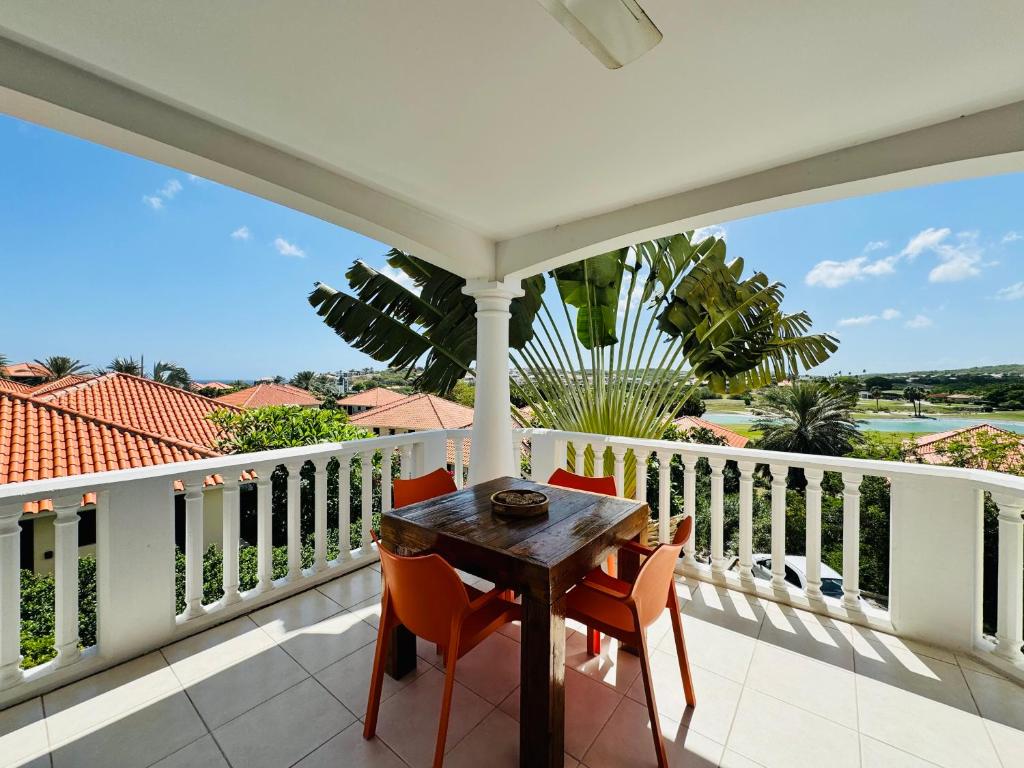 een veranda met een tafel en stoelen op een balkon bij # Blue Bay Beach - Ocean View Apartments # in Blauw Baai