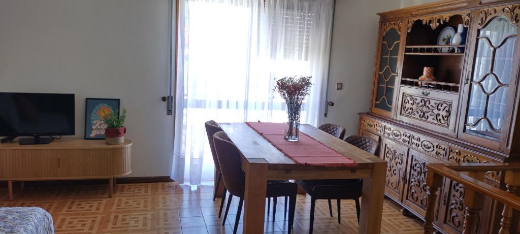 een eetkamer met een tafel, stoelen en een televisie bij Casa Golfinho (Norte) - Costa Nova in Costa Nova