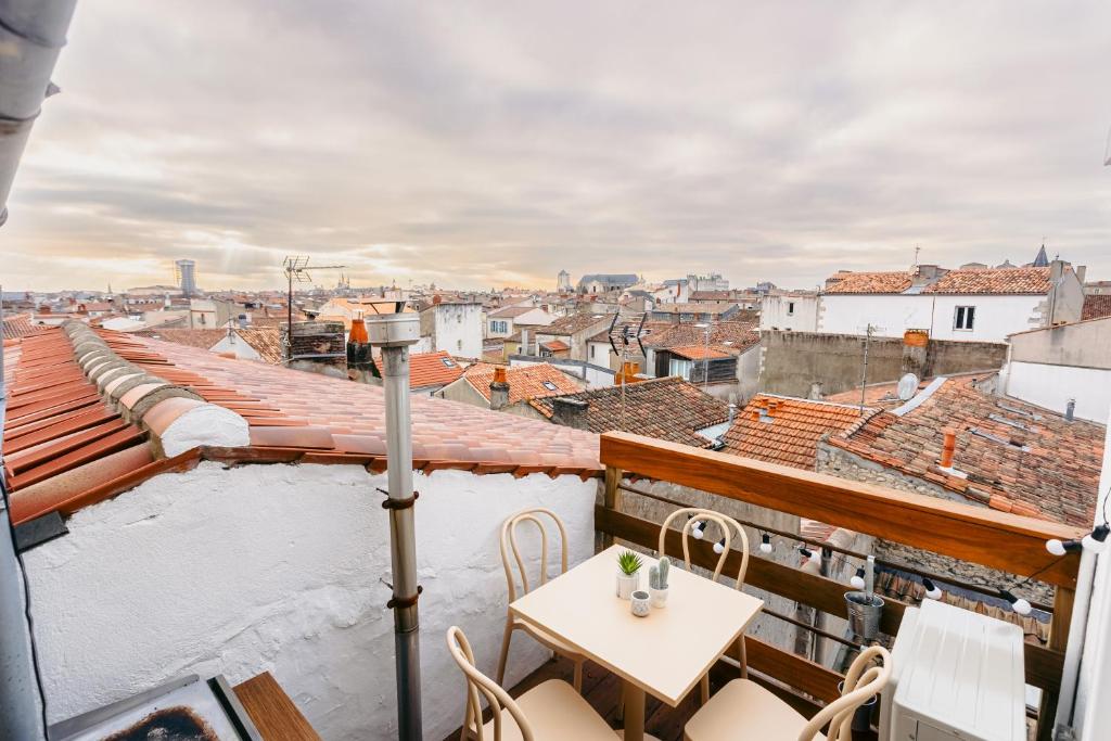a balcony with a table and a view of a city at Élégance Rochelaise avec Terrasse in La Rochelle