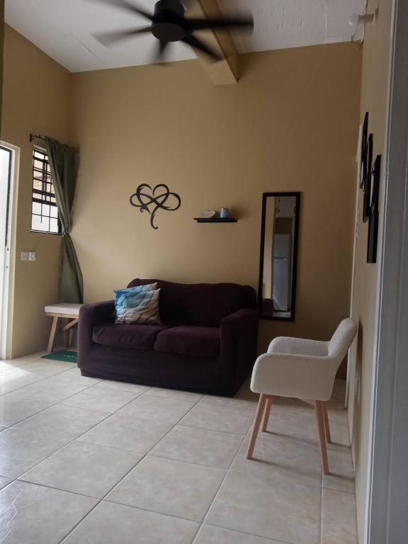 uma sala de estar com um sofá e uma ventoinha de tecto em Cozy Apt 15 minutes to Castries Ferry & Rodney Bay em Castries