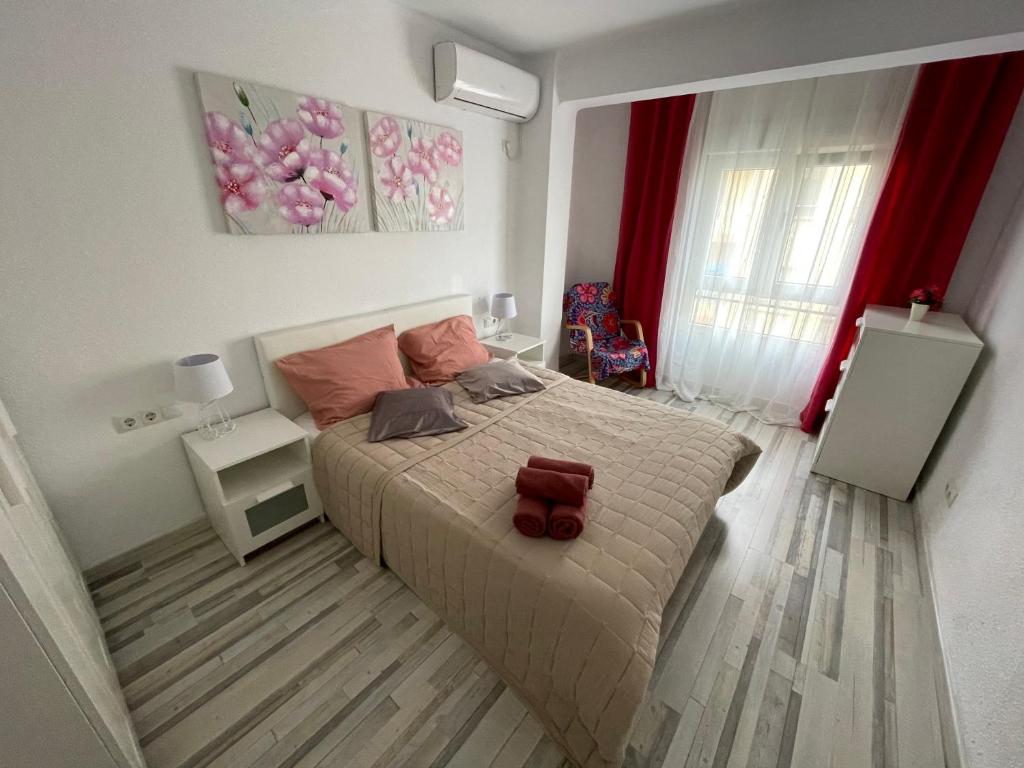 1 dormitorio con 1 cama grande con almohadas rosas en Piso tranquilo y luminoso en Valencia, en Valencia