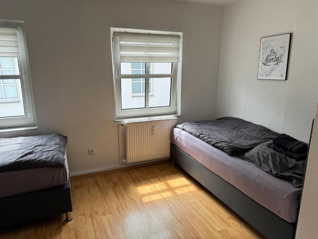 a bedroom with two beds and two windows at city apartment nice & comfy in Krefeld