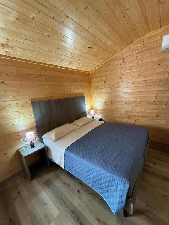a bedroom with a bed in a wooden cabin at Lido Tirreno beach in Campora San Giovanni