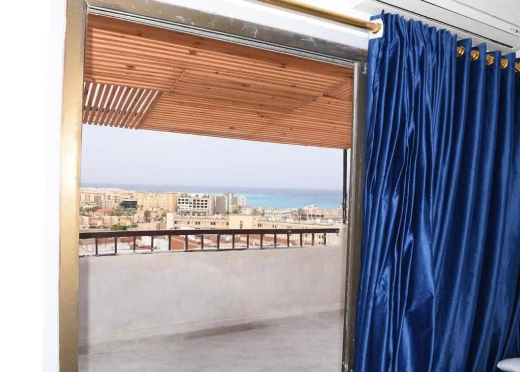 a view from a balcony with a blue curtain at El Kasr Hotel in Marsa Matruh
