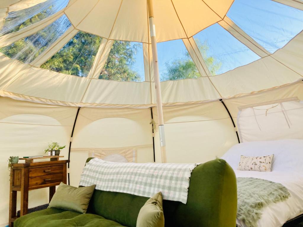 Habitación con cama en una tienda con ventanas en Luxury Stargazing Glamping - Seren Aur with Hot Tub, en Llanidloes