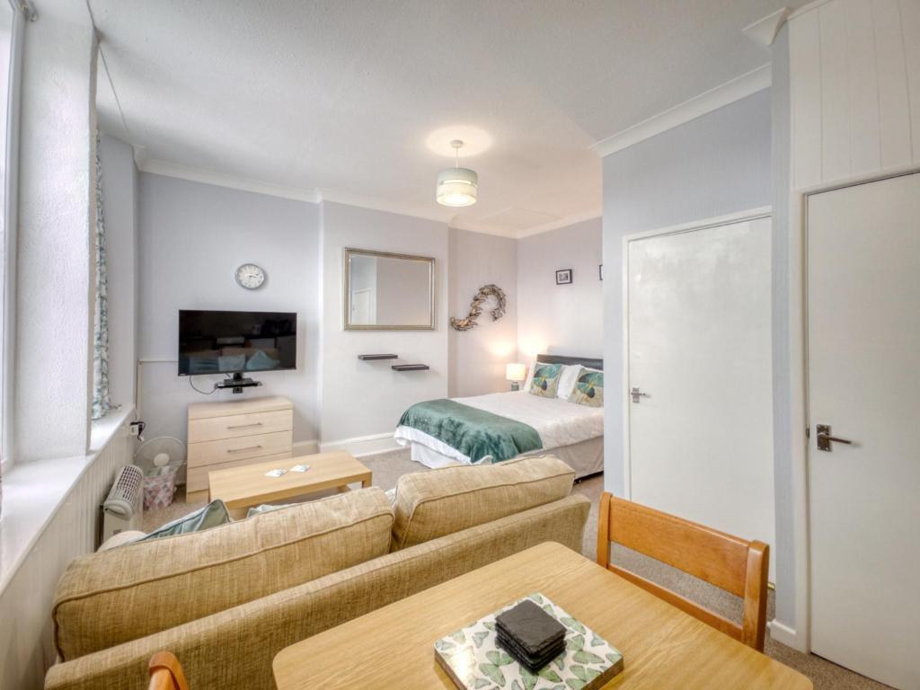 sala de estar con sofá y cama en Apartment 4 - Large studio - Sea Front location - Rear views-Free Parking, en Paignton
