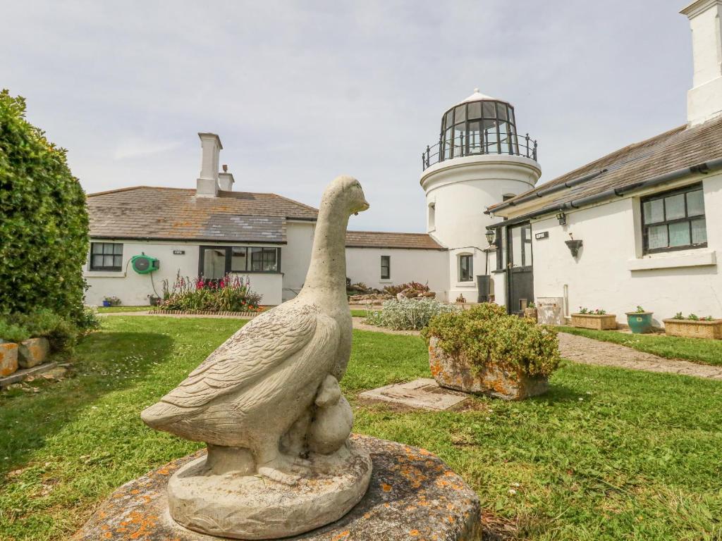 a statue of a duck in front of a house at Old Higher Lighthouse Stopes Cottage in Southwell