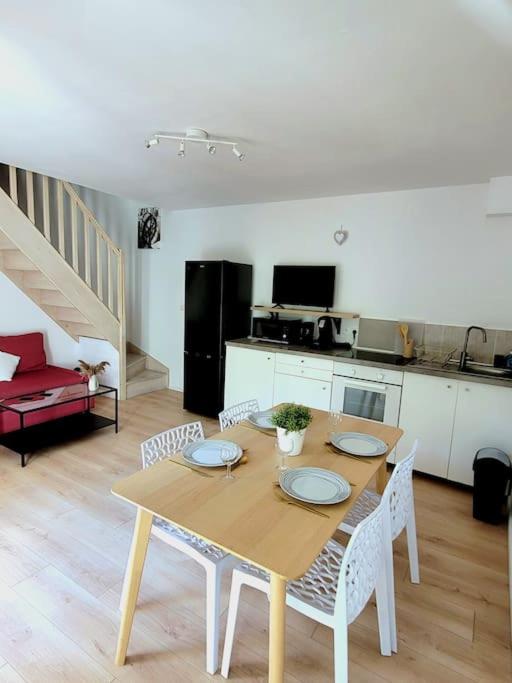 une table à manger et des chaises dans un salon dans l'établissement Joli duplex avec terrasse et parking, à La Rochelle