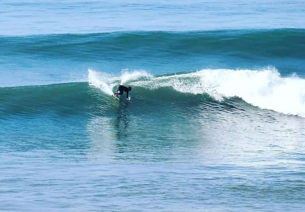 a person riding a wave on a surfboard in the ocean at apartment vue Mer in Agadir