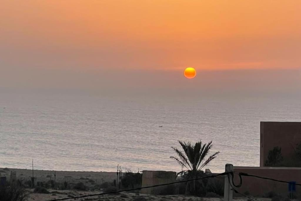 a sunset over the ocean with the sun in the sky at apartment vue Mer in Agadir
