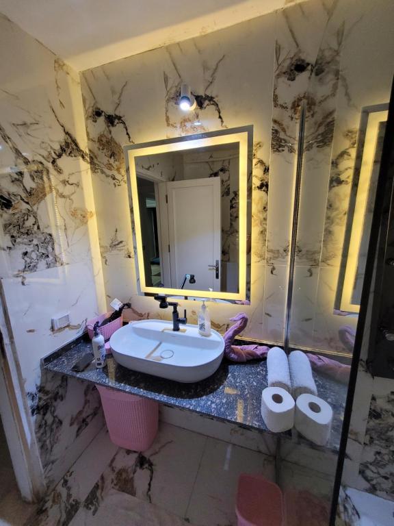 New Marina Hurghada Suite في الغردقة: حمام مع حوض ومرآة