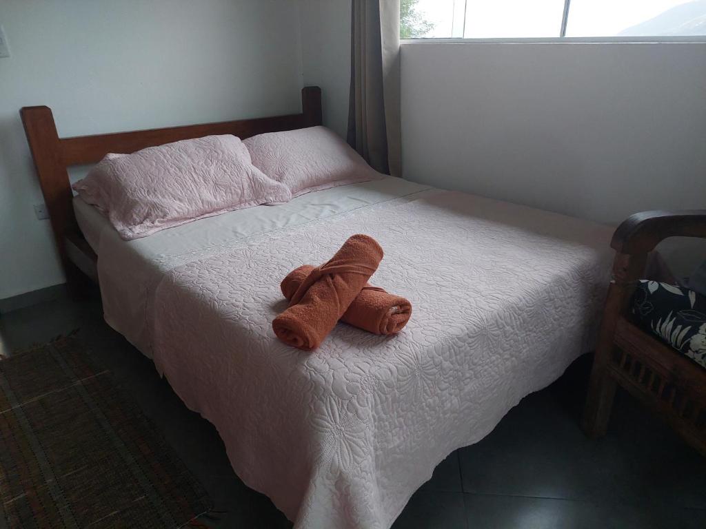 a stuffed animal is sitting on a bed at Casa temporada Ilhabela in Ilhabela