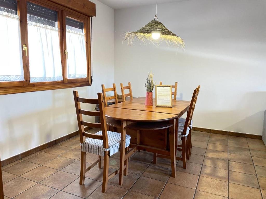 Un comedor con mesa y sillas de madera. en Casa La Divisa, en Boceguillas