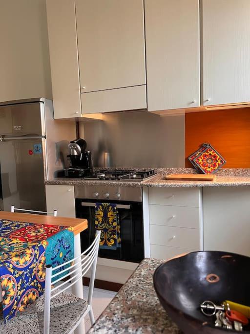 a kitchen with white cabinets and a table and a stove at Casa di Fausto - CityLife Apartment in Milan