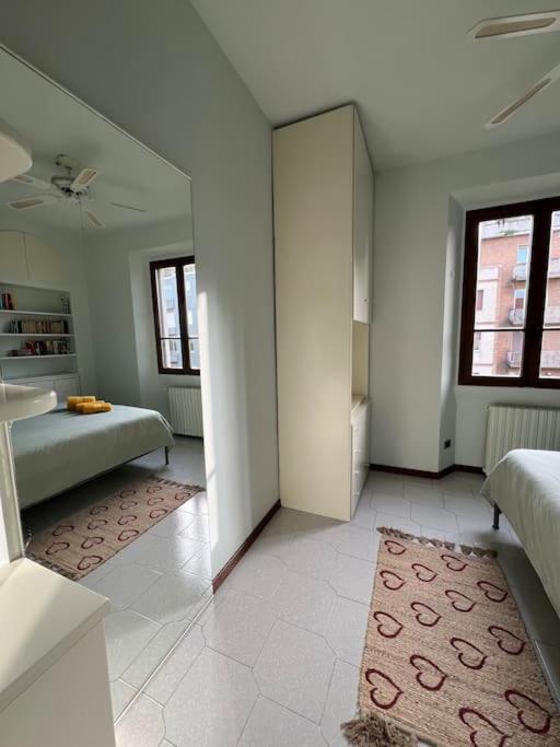 a large white room with two beds and a rug at Casa di Fausto - CityLife Apartment in Milan