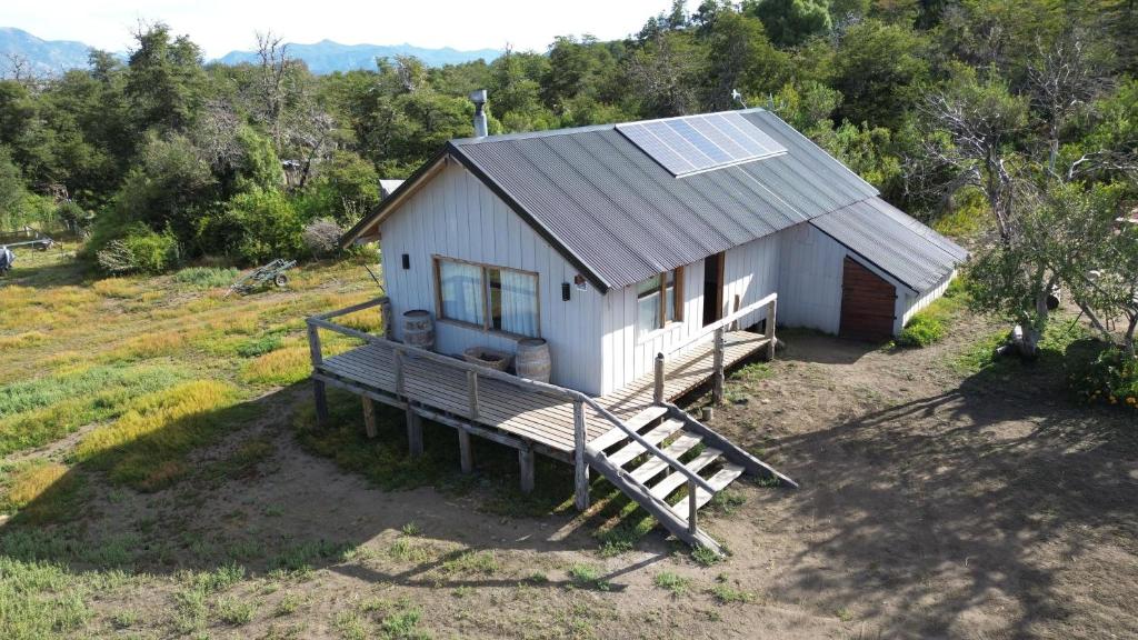 uma pequena casa com um alpendre e um telhado solar em Cabaña El Maqui em San Martín de los Andes